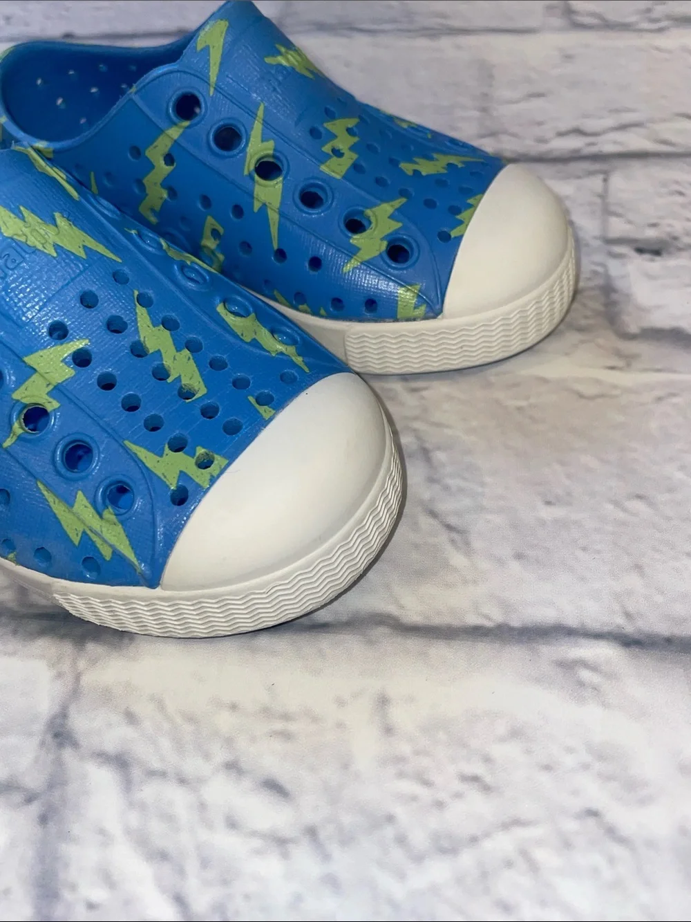 Native Jefferson Blue Slip-On with Neon Lightning Bolts. Size 5